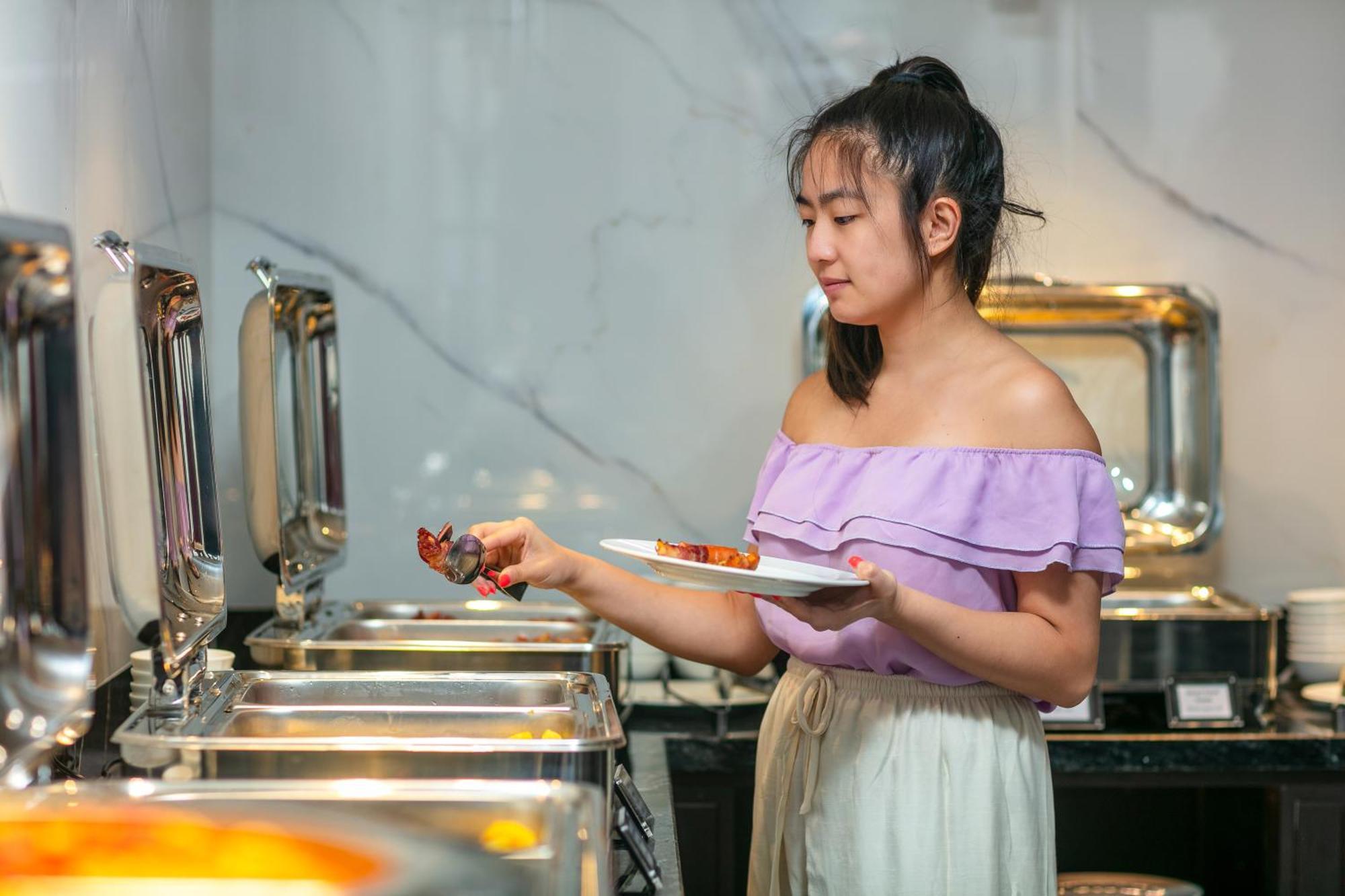 May De Ville Lakeside Hotel Hanoi Esterno foto A woman serving herself at a buffet